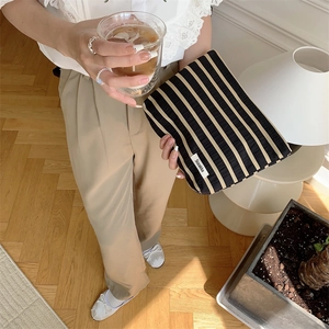 Close-up of lifestyle scene featuring black and yellow striped travel toiletry bag