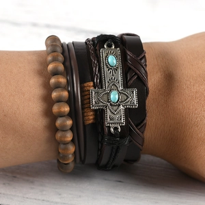 Close-up of multilayer leather bracelet featuring a metal cross and turquoise beads