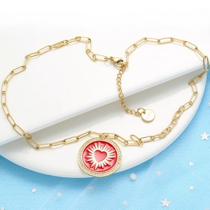 Gold stainless steel link chain necklace featuring a red round sunburst heart pendant