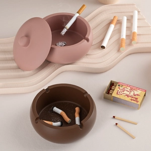 Vue détaillée des pots à bougies en céramique mate rose et marron sur socle ondulé