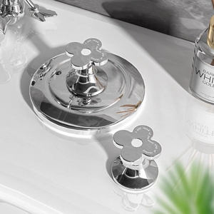 Silver flower toilet flush button extension with engraved quote on white vanity surface
