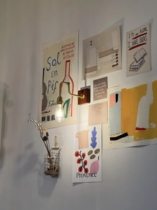 Detail of retro wall lamp with brass arm and wood base on an artful gallery wall