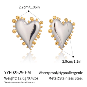Vue macro de boucles d'oreilles cœur géométriques argentées avec bordure dorée