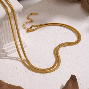 Zweilagige goldene Schlangenkette aus Edelstahl in Herzform auf weißem Untergrund