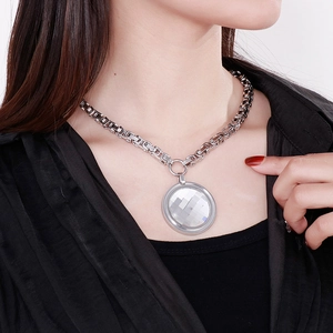 Close-up of a silver stainless steel chunky chain necklace with a round faceted pendant
