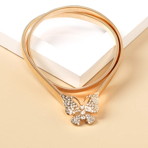 Detailaufnahme der goldenen Schmetterlingsschnalle mit Kristallen am elastischen Gürtel