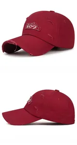 Close-up of distressed cotton baseball cap in burgundy with vintage letter patch embroidery