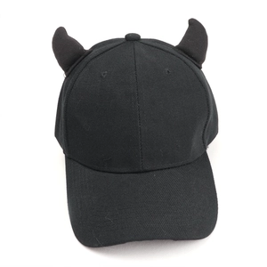 Close-up of black baseball cap featuring 3D devil horns and cotton twill texture