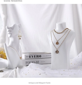 Detail of gold layered world map necklace on a white minimalist mannequin display