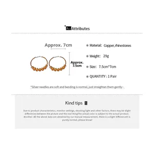 Détail de boucles d'oreilles pendantes de 7,5 cm avec tige en argent et strass ambrés