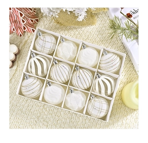 Macro view of 12 white velvet Christmas balls with gold glitter in a gift box