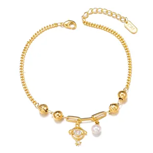 Detailed close-up of a layered gold chain bracelet with pearl and planet pendant Charms