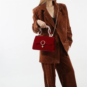 Red velvet wedding handbag with pearl handle and golden heart lock shown on model