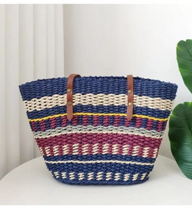 Detail of colorful striped woven tote bag featuring brown leather straps and gold rivets