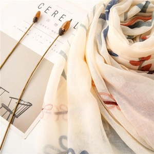 Detail of floral beige scarf with abstract stripes next to Cereal magazine and dried flowers
