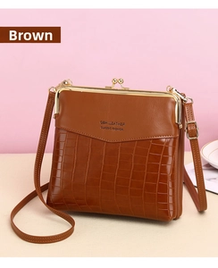 Close-up of retro brown crocodile texture on crossbody bag with gold kiss-lock