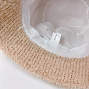 Detail shot of the warm beige faux shearling fisherman hat with soft inner lining and tag