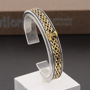 Nordic Mjolnir stainless steel bangle featuring golden Celtic knots and Thor's hammer motif