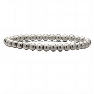 Détail macro d'un bracelet en perles argentées avec des billes métalliques réfléchissantes