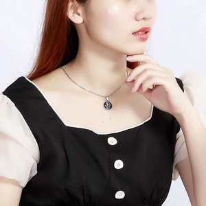 Silver stainless steel chain necklace with circular Tree of Life pendant on model