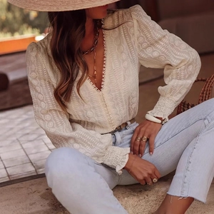 Close-up of elegant V-neck lace embroidery and intricate sleeve details on a white blouse