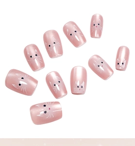 Close-up of pink cat-themed press-on nails with cute cat faces and pearl finish