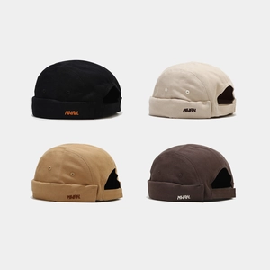 Détail de la broderie MWAH sur des bonnets docker en coton noir, beige, kaki et marron