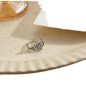 Vintage oxidized silver ring with intricate Celtic knot patterns on a ceramic plate