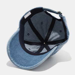 Detail view of denim baseball cap interior with sweatband and adjustable metal buckle