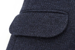 Détail macro du rabat de poche de veste en tweed bleu foncé et texture en laine