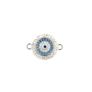 Macro shot of silver evil eye connector with blue enamel and sparkling zircons
