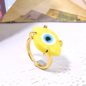 Close-up of golden adjustable ring featuring a vibrant yellow evil eye glass inlay