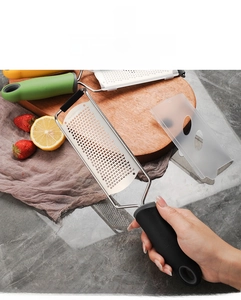 Macro view of handheld stainless steel zester with ergonomic black non-slip handle