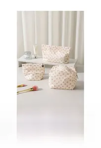 Ensemble de 3 trousses à maquillage fleuries avec différentes tailles sur un bureau chic