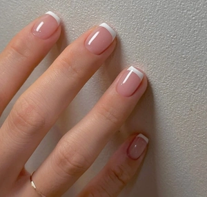 Close-up of pink French press-on nails with white tips in short square oval shape