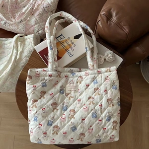 Detailed texture of quilted cotton tote bag with cute animal prints and French fabric label