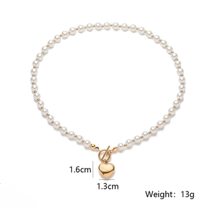 Gold plated heart pendant necklace with pearl accent and toggle clasp on white background