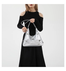 Detail of silver underarm bag with decorative 3D butterflies and adjustable strap