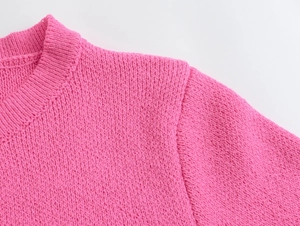 Detail of pink knit cardigan showing round neckline and premium shoulder stitching