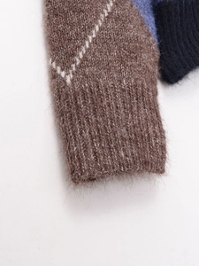 Dettaglio ravvicinato del polsino in maglia a rombi con texture in mohair e bordo a coste
