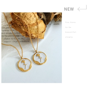 Detail of vintage gold-plated necklaces with rose relief on white enamel charms