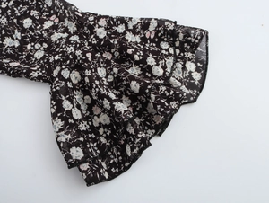 Detailed shot of multi-layer bell sleeves with pink floral print on black fabric