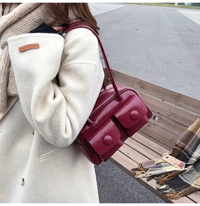 Detail of burgundy glossy PU shoulder bag featuring double pockets and vintage design