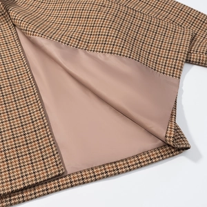 Detailed view of brown houndstooth wool jacket showing smooth inner lining and neat stitching