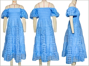 Detail of light blue off-shoulder dress featuring puff sleeves and tiered lattice fabric