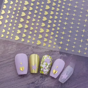 Detailed view of golden heart and star nail stickers applied on manicured purple nails