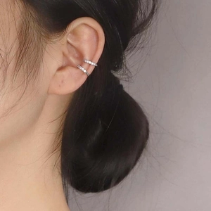 Close-up of double-loop silver ear cuffs with micro-pave zircons on a female model