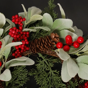 Artificial Christmas wreath featuring pine cones, red berries and green pine needles