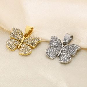 Macro view of gold and silver butterfly pendants with pave crystal embellishments