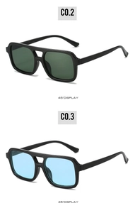 Detail view of square sunglasses with double-bridge frames in dark green and light blue lenses